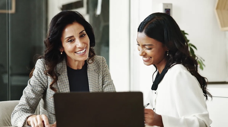 Two colleagues reviewing talent data together on a laptop